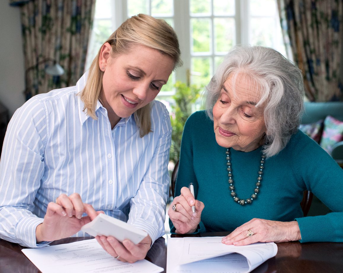 Elderly woman signing springing power of attorney form with notary public